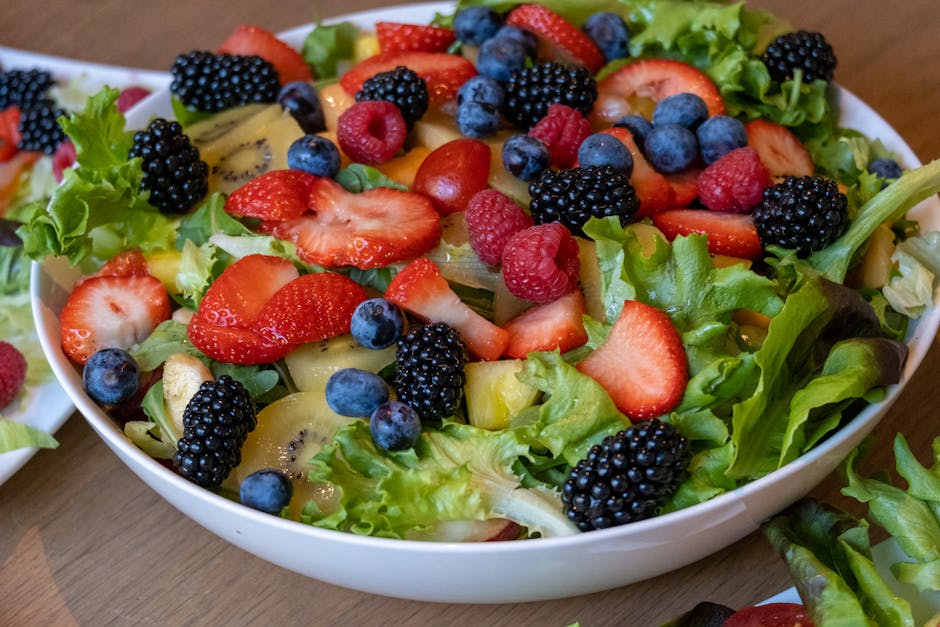 Bol coloré de salade de fruits avec fraises, kiwis et baies