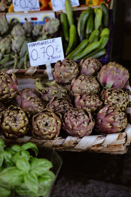 Basket of fresh artichokes on display at a vibrant market stall.