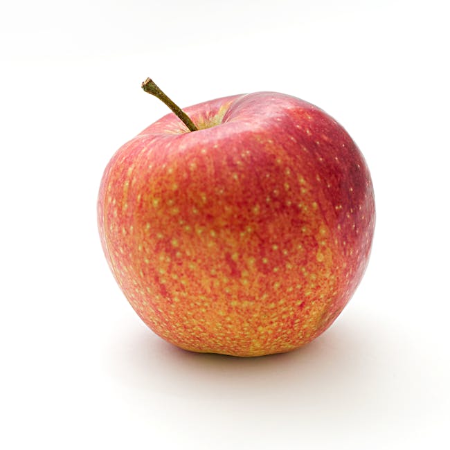 Close-up of a vibrant red apple with a stem, isolated on a white background.
